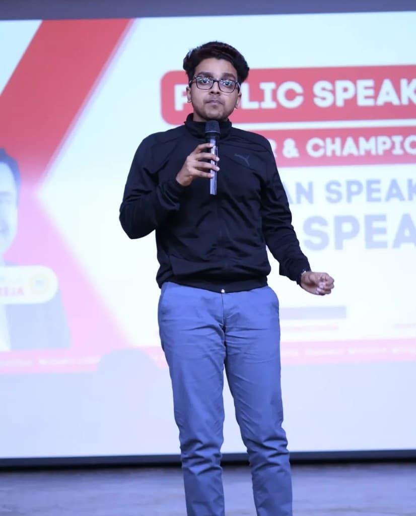 NexTechVion leadership presenting on stage with a microphone at a public speaking event